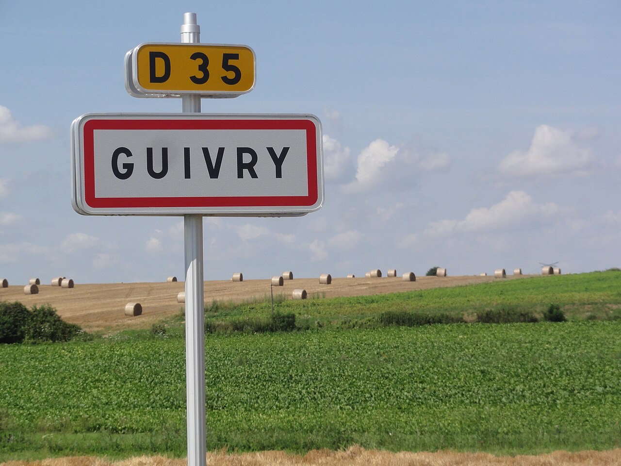 Panneau d'entrée du village de Guivry sur la route départementale 35, au milieu des champs
