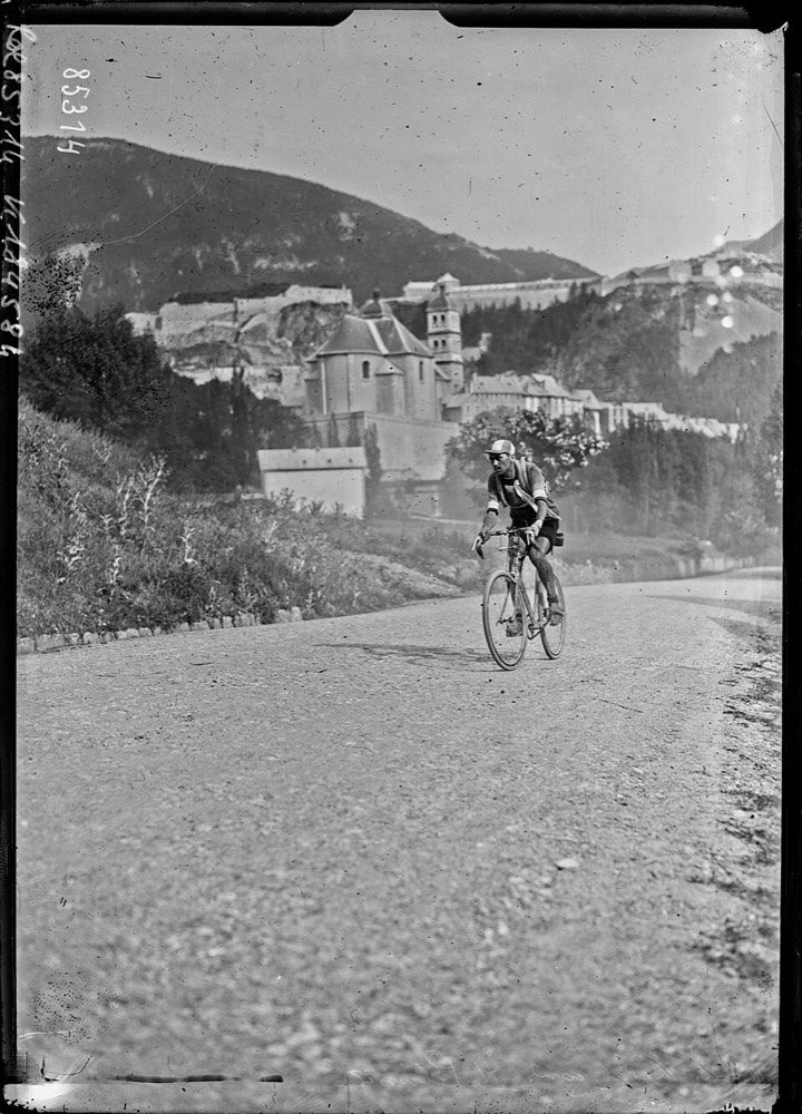 Henri Pélissier seul à vélo sur une route de montagne à Briançon, en 1923